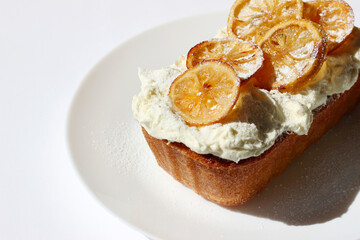 Lemon Cake with Butter Cream Topping Decorated with Candied Lemon Slices. Delicious Freshly Baked Dessert on White Plate. Pastry Food Styling.
