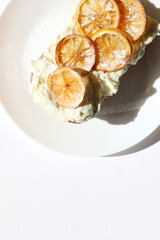 Desserts. Lemon Cake with Butter Cream and Caramelized Lemon Slices on White Background. Holidays Celebration Pastry.
