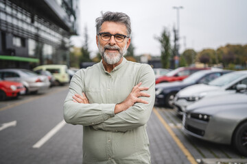 Portrait of man businessman arm crossed stand on the parking lot