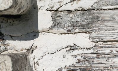 A fragment of the wall of an old wooden house with whitewash