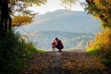 Mother and Daughter Walk Hand-in-Hand Through an Enchanting Autumn Landscape, Creating Memories