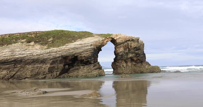 Natural rock arch on famous Playa de Las Catedrales (Beach of the Cathedrals) in Ribadeo, Galicia, Spain
