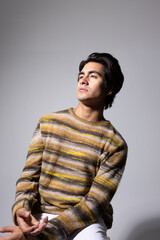 Obraz premium Young man with dark hair posing over white background. Vertical.
