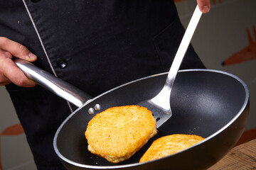 chef making potato pancakes in kitchen