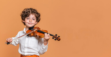 Cute boy violinist plays violin on orange background. Banner with space for text