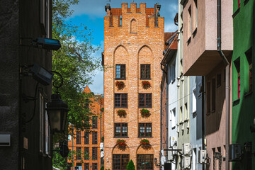 Sunlight bathes the historic brick buildings of gdansk, poland, showcasing the city's rich architectural heritage and creating a picturesque scene
