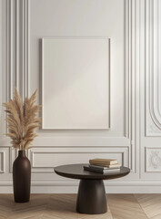  Large white picture frame on an empty wall with a round table in front holding books and a vase, in a minimalistic interior. Perfect for design visuals or modern decor themes