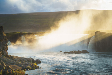 Majestic Goðafoss waterfall at sunset, with cascading waters of the Skjálfandafljót River, in northern Iceland.