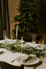 Vertical shot of dining room with fur tree and served table for Christmas eve