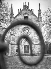 close up view to facade of catholic church in monochrome style from gate curved part