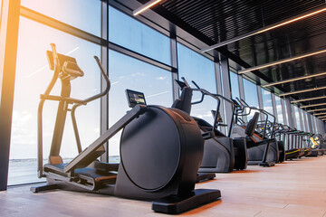 Modern light gym. Sports equipment in gym. Elliptical trainer