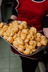 Freshly baked choux pastries on a tray, perfect for desserts or bakery displays