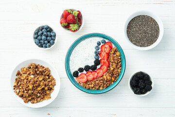 Healthy breakfast . Yogurt with berries ( strawberry , raspberry , blueberry , blackberry ) , granola and chia seeds . Top view