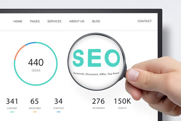 Computer screen displaying SEO data with magnifying glass highlighting keywords, symbolizing research, keyword search, and analytics in digital marketing