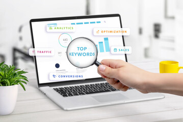 Search for top keywords displayed on laptop screen with keyword statistics, surrounded by icons for analytics, traffic, conversions, optimization, and sales