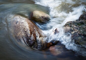 the water of the river flows around the stones