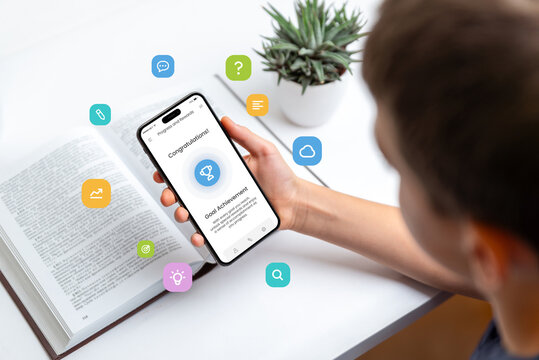 Student studying with smartphone displaying trophy for goal achievement, symbolizing progress tracking and gamification of tasks