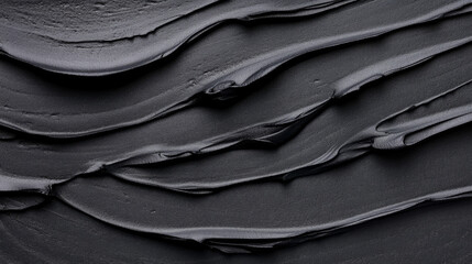 Fototapeta premium Thick black texture spread on a surface, showcasing smooth layers and depth