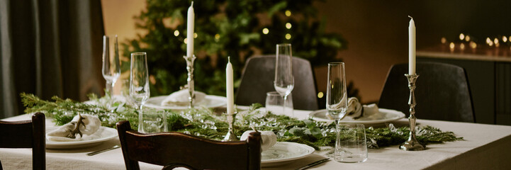Website banner with served table decorated with pine garland in center of it for X-mas party