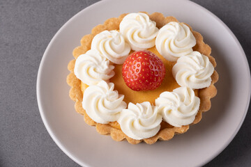 Freshly made strawberry tart on a grey table setting