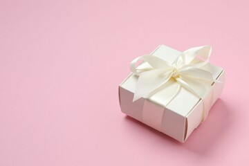 Beautiful gift box tied with bow on color background 