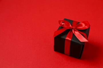 Beautiful gift box tied with bow on color background 