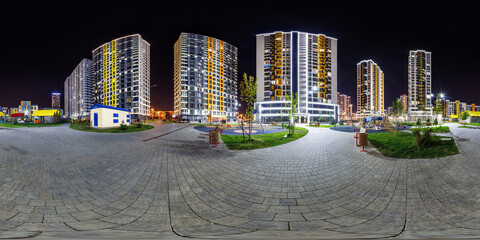 night panorama 360 near skyscraper multistory buildings with illumination of residential quarter complex in full equirectangular seamless spherical projection.