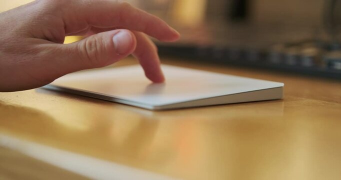 Male hand uses the trackpad, finger presses on the touchpad surface, computer with special multi-touch gestures. Close-up