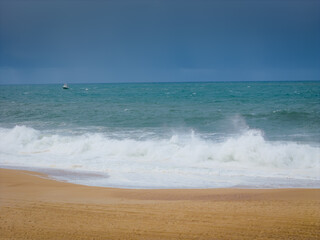 Breaking waves at Nazare beach on the Portugal coastal town on the Atlantic ocean shore. Aerial drone view