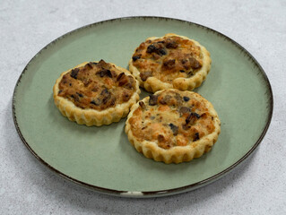 Gourmet mini tarts. Closeup view of fresh baked smoked salmon pies