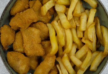 Fast food. Top view of a fried fish nuggets and fried potatoes