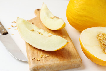 Fresh ripe melons and knife on white table