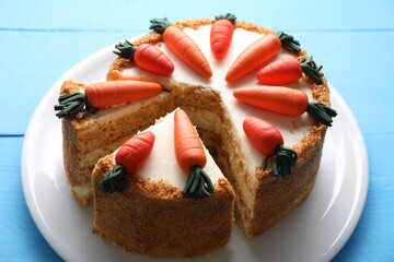 Plate with delicious carrot cake on blue wooden table, closeup