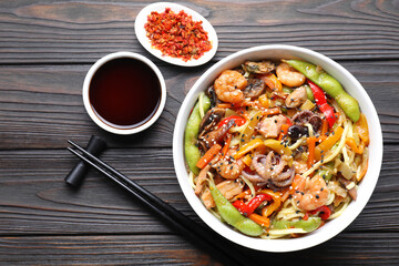 Stir-fry noodles with sea food served on wooden table, flat lay