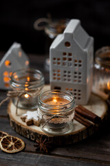 Creating holiday mood, festive atmosphere at home. Christmas spirit, atmospheric composition with handmade aroma candles made from simple glass jars, homemade gingerbread cookies, anise cinnamon scent