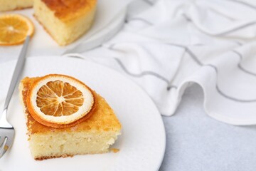 Slice of tasty semolina cake served on white table, closeup. Space for text
