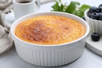 Tasty semolina cake served on white tiled table, closeup