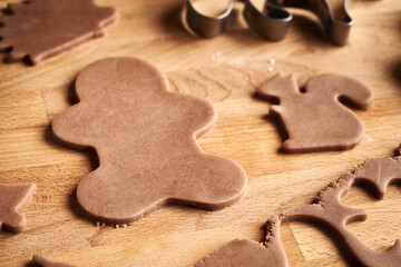 Shapes cut out from raw pastry dough - preparation of homemade gingerbread Christmas cookies