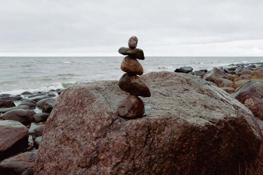 The stones of the pyramid balance on the rock. Sea, time for meditation.
