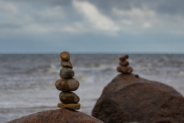 The stones of the pyramid balance on the rock. Sea, time for meditation.