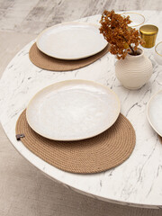 Beautiful table setting. Handmade jute wicker placemats, plates and small vase