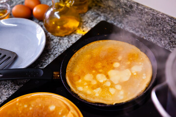 Delicious pancakes fried for breakfast in frying pan in kitchen..