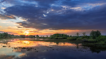 Beautiful sunset over a lake with trees in the background