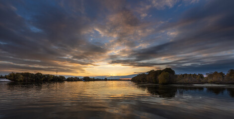 The sky is cloudy and the sun is setting