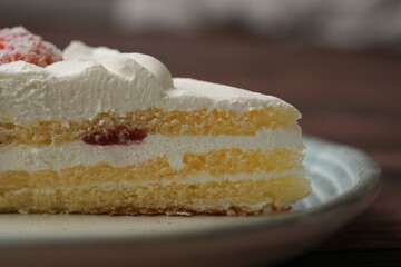 One small Japanese strawberry shortcake on a stylish Japanese plate on a brown wooden deck