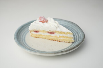 One small Japanese strawberry shortcake on a stylish Japanese plate on a white table