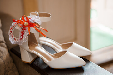 Elegant White Bridal Shoes with a Garter and Ribbon Detail
