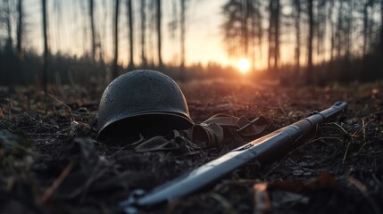 Fototapeta premium A soldier's helmet and bayonet rest somberly on a forest floor at sunrise, evoking memories of past conflicts and quiet reflection on sacrifice.