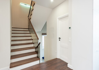 Living room interior in new luxury home with open concept floor plan. Features stairs to second story