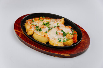 Delicious baked potatoes with melted cheese and herbs served on a wooden platter, comfort food